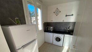 A compact kitchen with a washing machine, a microwave, and a refrigerator. - Beachfront apartment for 4 with loggia in Argelès-sur-Mer (Argelès-sur-Mer)