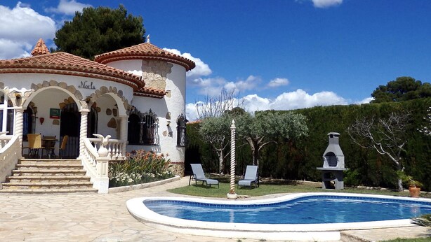 Una villa con piscina, escalones de piedra y zona de estar exterior.