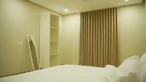 Habitación de hotel con cama, armario y espejo.