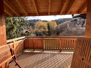 A wooden deck with a view of a mountainous landscape and autumn foliage. - New 78m² duplex, 2 bedrooms, pellet stove, WIFI, parking, sleeps 5 - Arâches-la-Frasse (Arâches-la-Frasse)