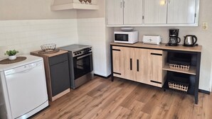 A compact kitchen with white cabinets, a microwave, a coffee maker, and a dishwasher. - Spacious 4-bedroom apartment with balcony and WIFI, near Châtel and La Chapelle (Abondance)