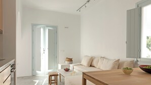 Ett modernt och minimalistiskt vardagsrum med en soffa, ett soffbord och ett matbord.