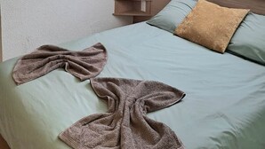 A bedroom with a bed, a ceiling fan, a window, and a wall-mounted shelf. - To complete (Colmar)