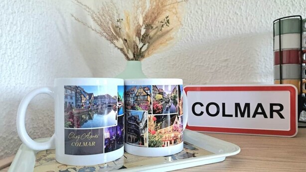 Two mugs with a collage of images, a nameplate with 'COLMAR' on it, and a vase with dried plants. - To complete (Colmar)
