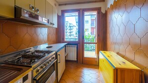 Eine kleine Küche mit Gasherd, Backofen und einer hölzernen Sitzbank.