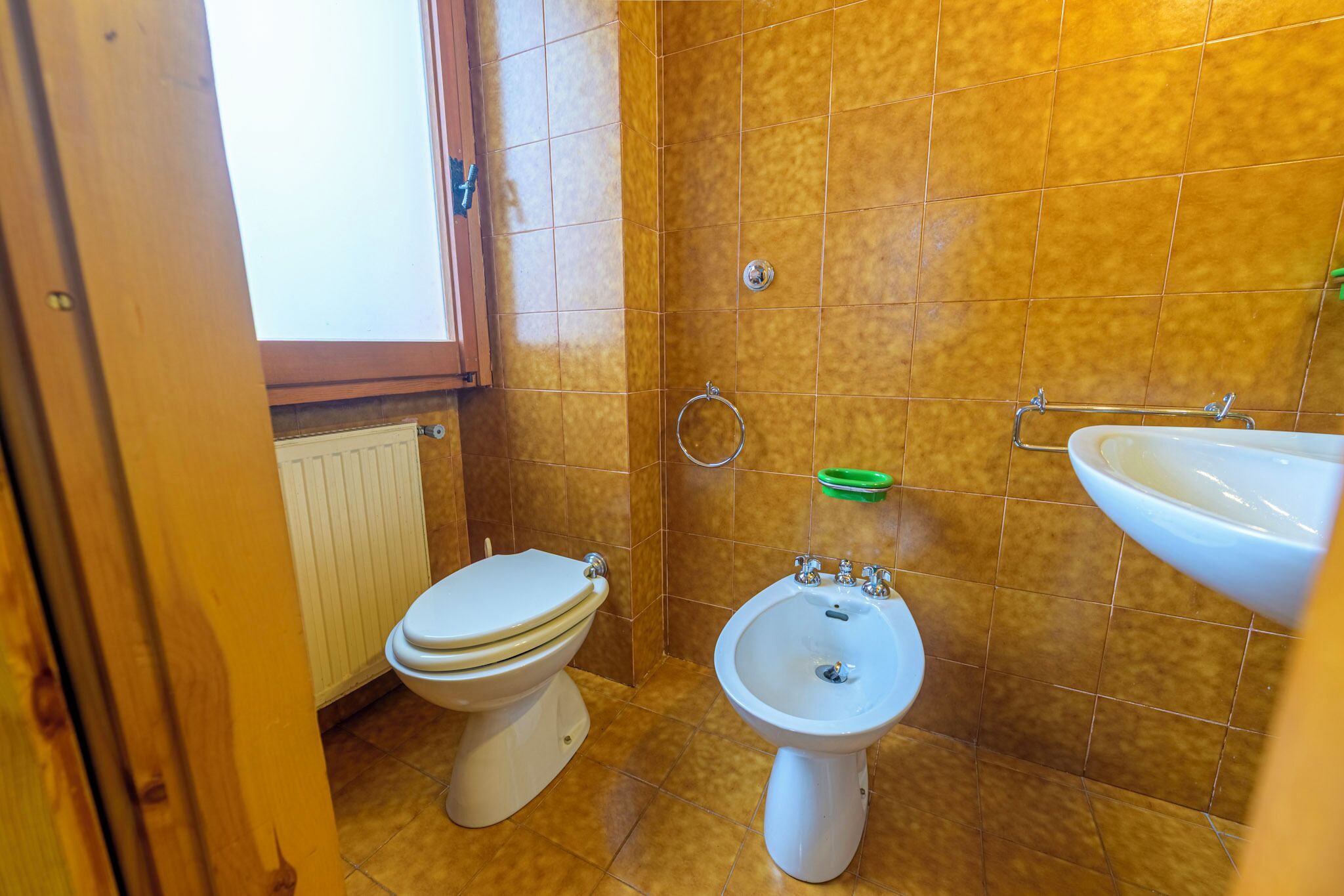 Un baño con inodoro, bidé y lavamanos.
