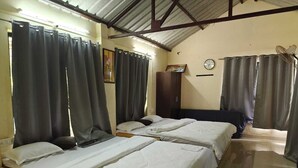 A room with three beds, a wardrobe, a clock, and a fan. - Rutuvan Resort Girivan (Paud)