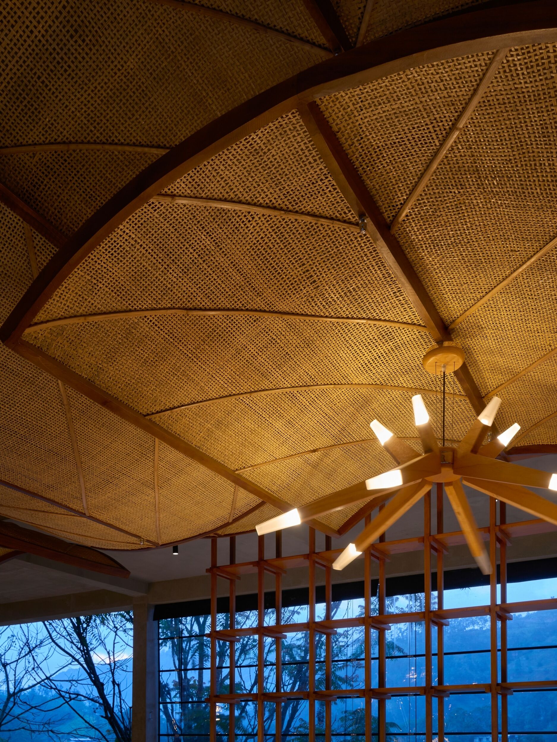 Une pièce dotée d’un plafond en osier et d’un ventilateur de plafond en bois.