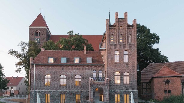 A large, historic building with a prominent tower and arched windows.
