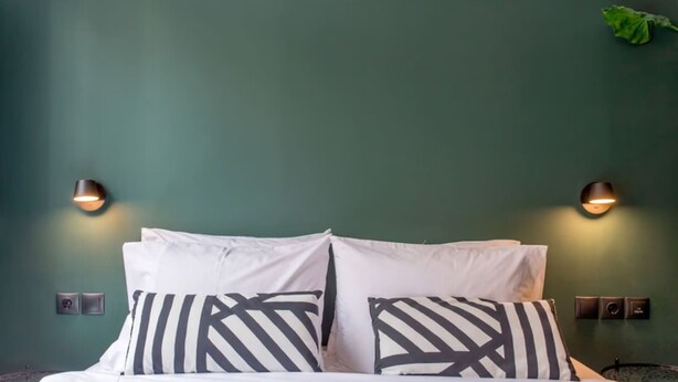 A bed with white bedding and black and white striped pillows, two wall-mounted lights, and a green wall. - 2 Bedroom in the Center of Thessaloniki! (Thessaloniki)