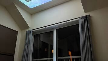 Chambre, véranda, vue jardin | Rideaux occultants, fer et planche à repasser