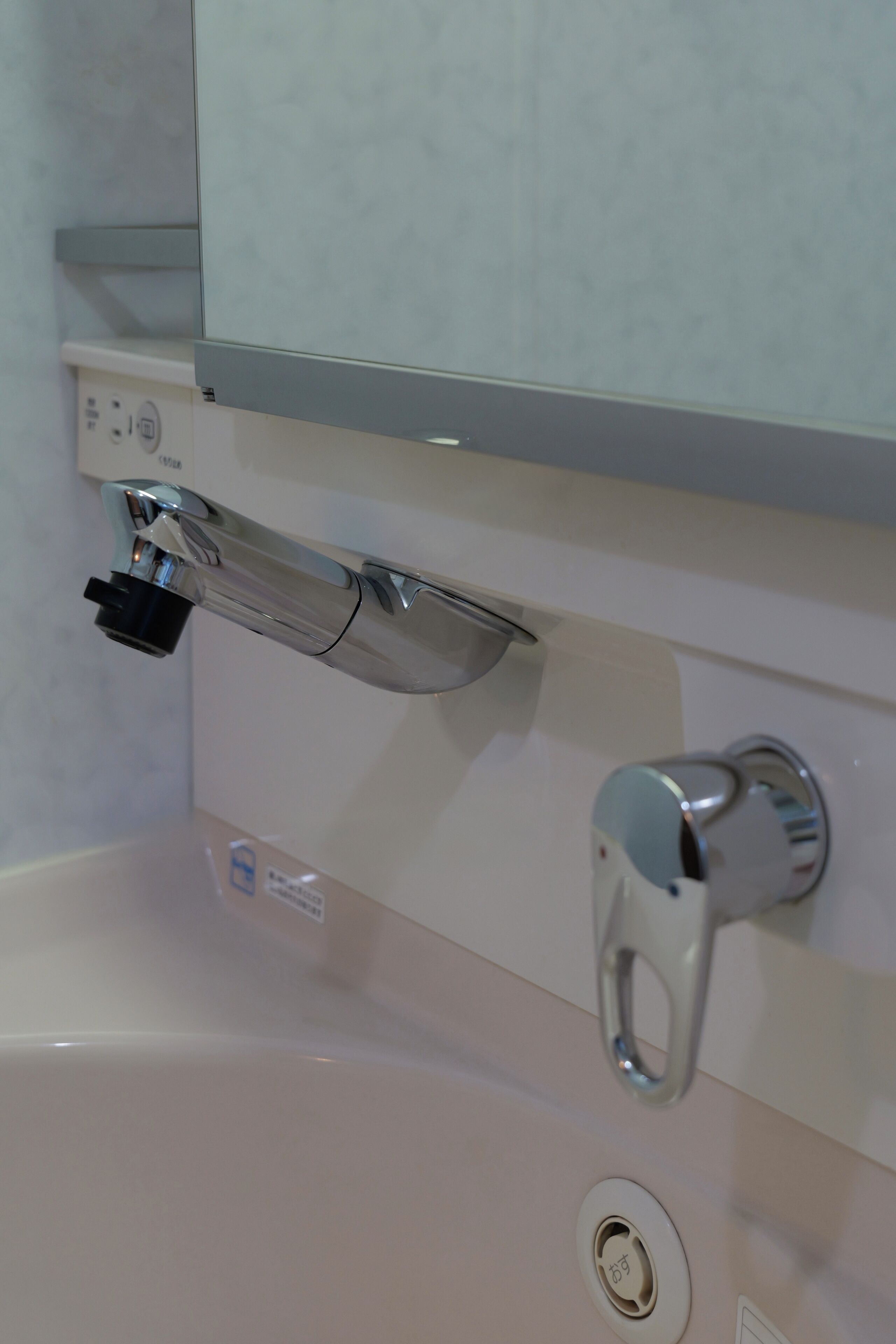 A bathroom with a sink, faucet, and a mirror.