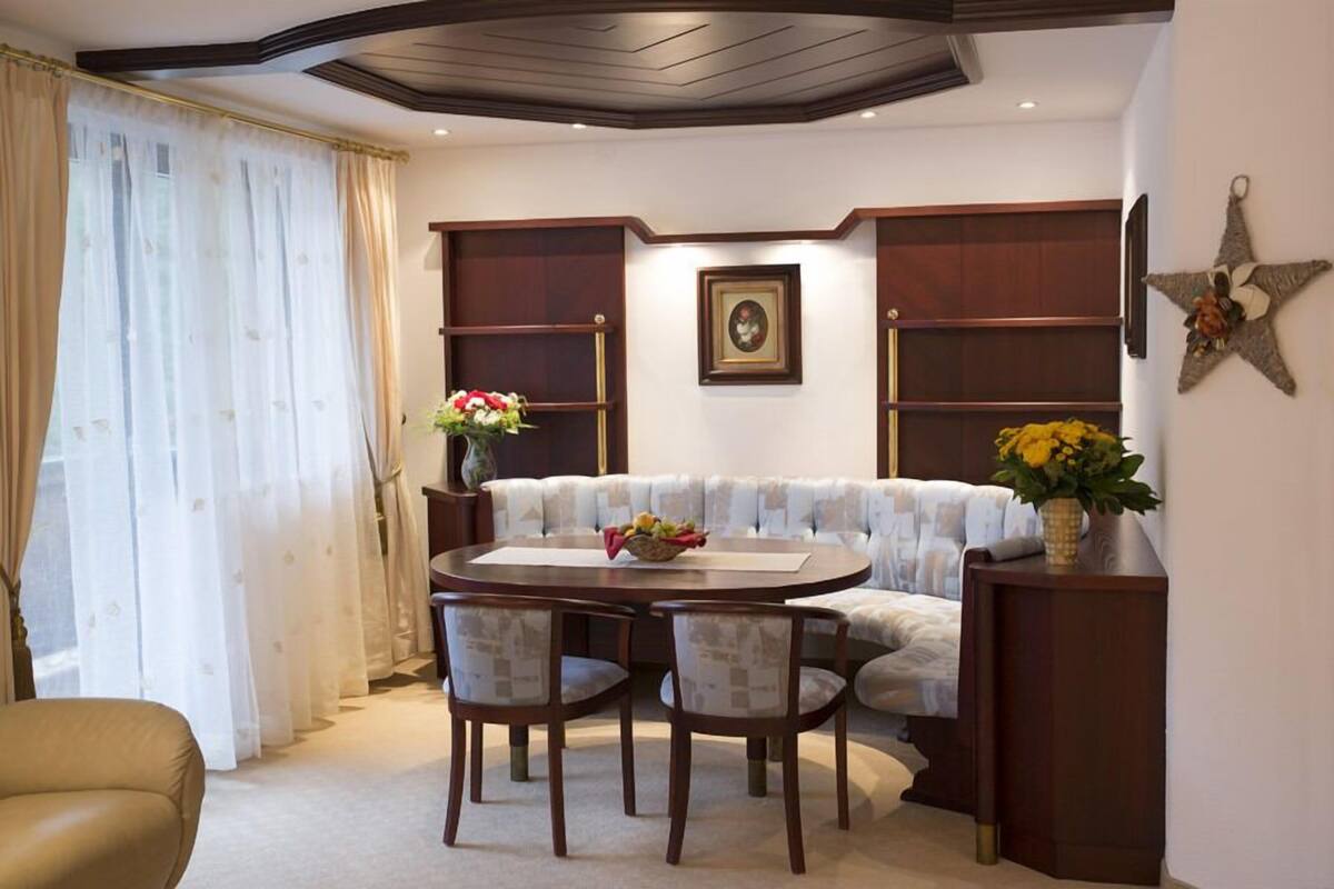 Un coin repas comprenant une table ronde, quatre chaises, un canapé et une étoile décorative accrochée au mur.