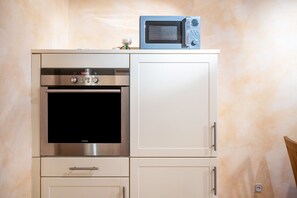 Een keuken met een ingebouwde oven en magnetron, een kast met een handgreep, en een stopcontact.
