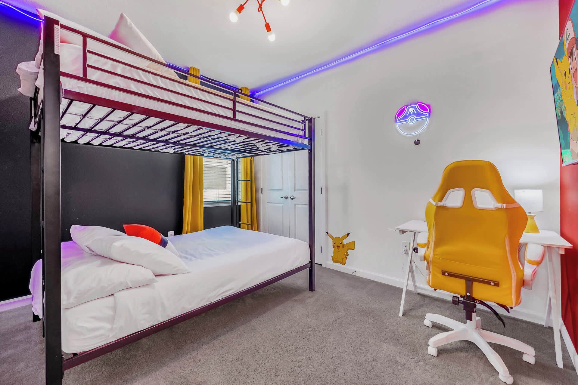 Camera con letto a castello, una scrivania, una sedia, una finestra con tende e un adesivo di Pikachu al muro.