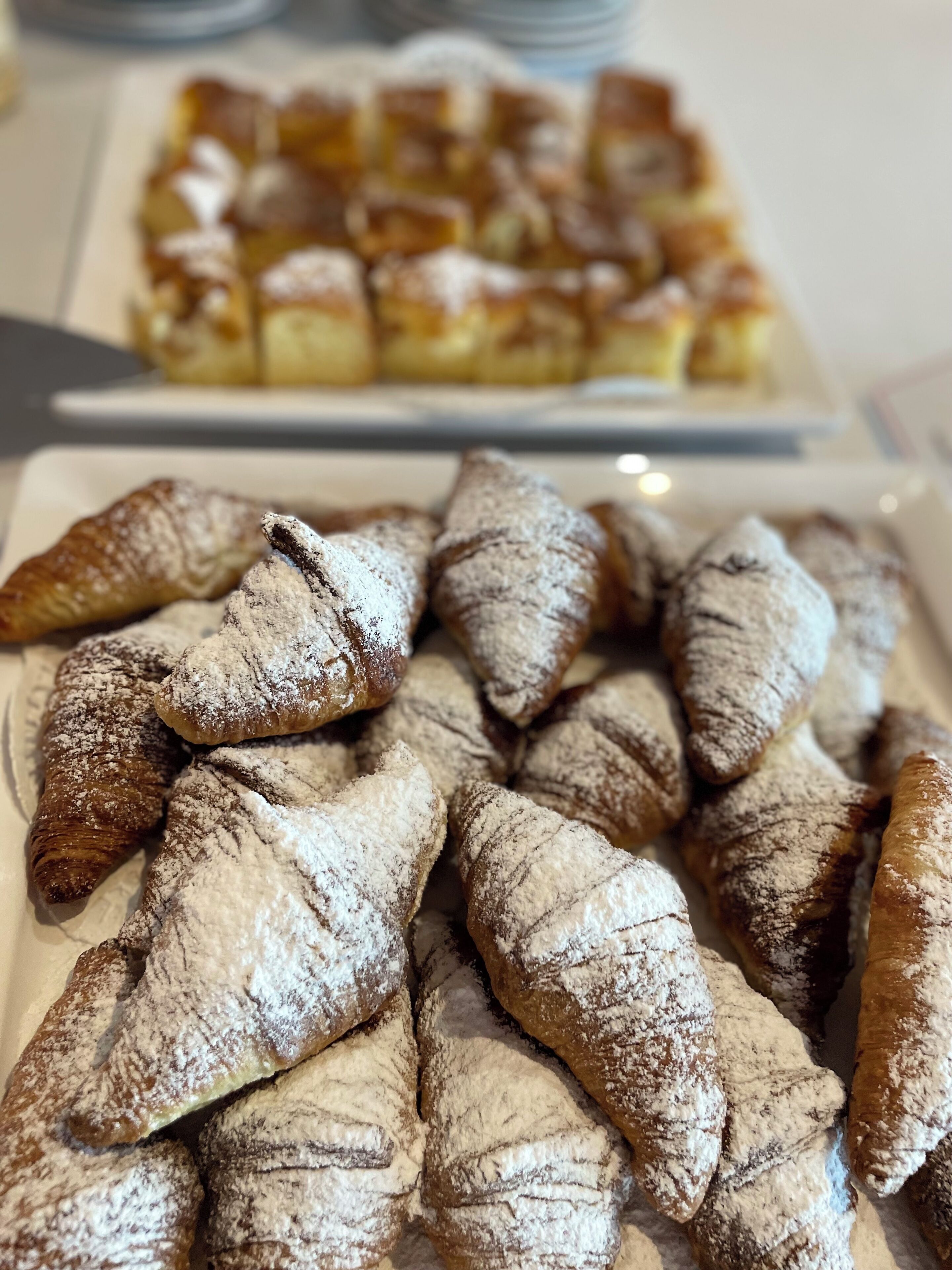 Diverses pastes, incloent croissants i altres productes de forneria, presentades en plats.