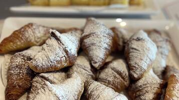 Diverse gebakjes, waaronder croissants en ander vers gebak, gepresenteerd op borden.