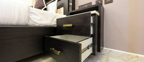 A bed with a headboard, a nightstand with a drawer, and a marble floor.