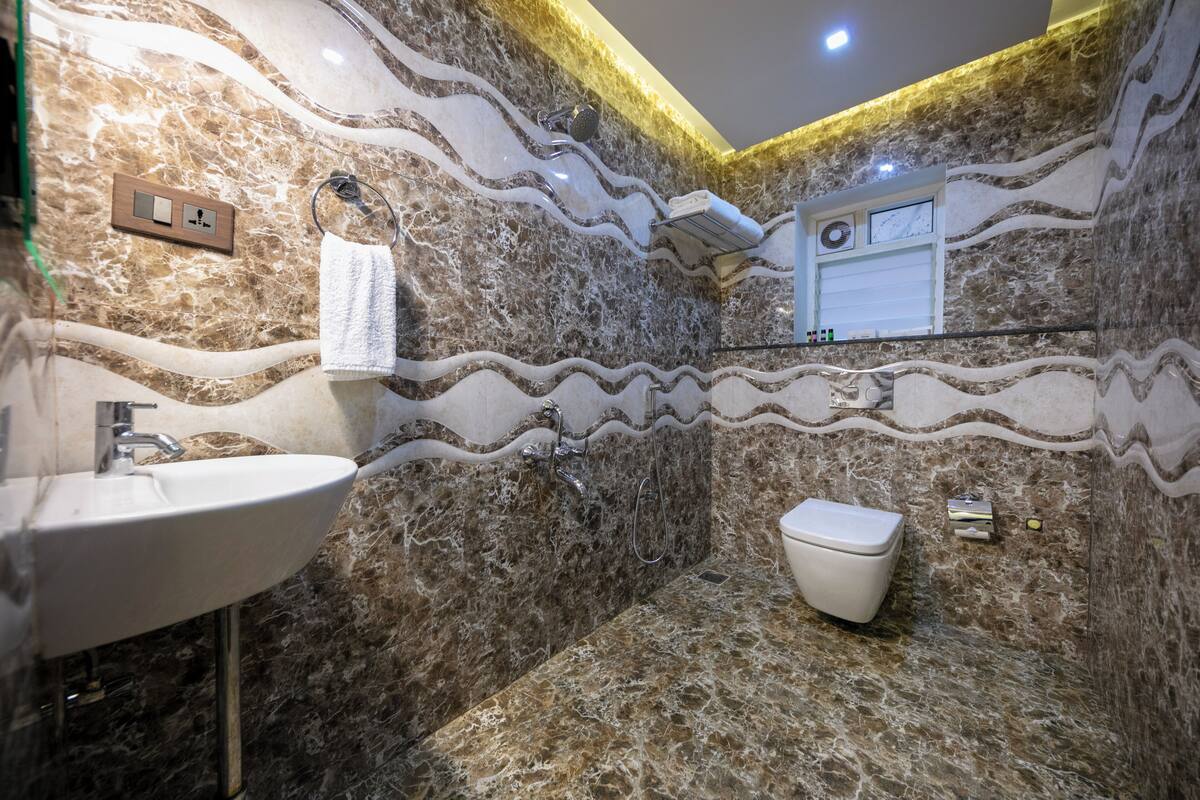 Ein Badezimmer mit Marmorwaschbecken, Toilette und Dusche.