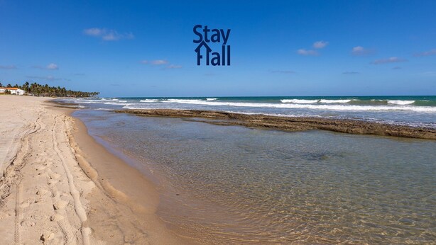 A beach with clear water, a sandy shore, and a 'Stay Hall' sign. - 014D-Village Praia dos Carneiros III (Tamandaré)