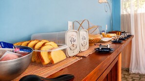 A buffet setup with bread, a container of meat, and a coffee station.