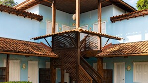 A building with a central staircase, multiple doors, and a tiled patio area.
