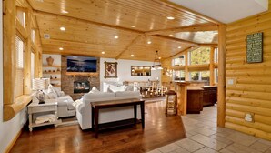 Ein geräumiges Holzblockhaus-Interieur mit Wohnbereich, Essbereich und Küche.