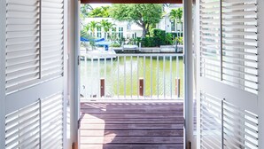 Eine Holzterrasse, die zu einem Wasserblick führt, mit Geländer.