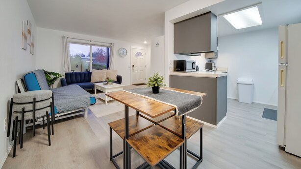 Un apartamento moderno con comedor, sofá, cocina y vistas al exterior.