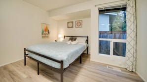 A bedroom with a bed, a window with curtains, and two wall decorations. - Eastside Tech Hub Home Base Near I-90 & Factoria! (Bellevue)