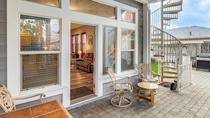 A covered patio with a dining area, a spiral staircase, and a view into the house. - Napa Nearby! Large Home w/ Hot Tub & Dtwn Access (Suisun City)