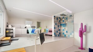 Un intérieur moderne comprenant une cuisine, un coin repas et une douche en verre.