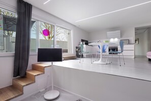 Eine moderne Küche mit Essbereich, einem Fernseher und einer Treppe.