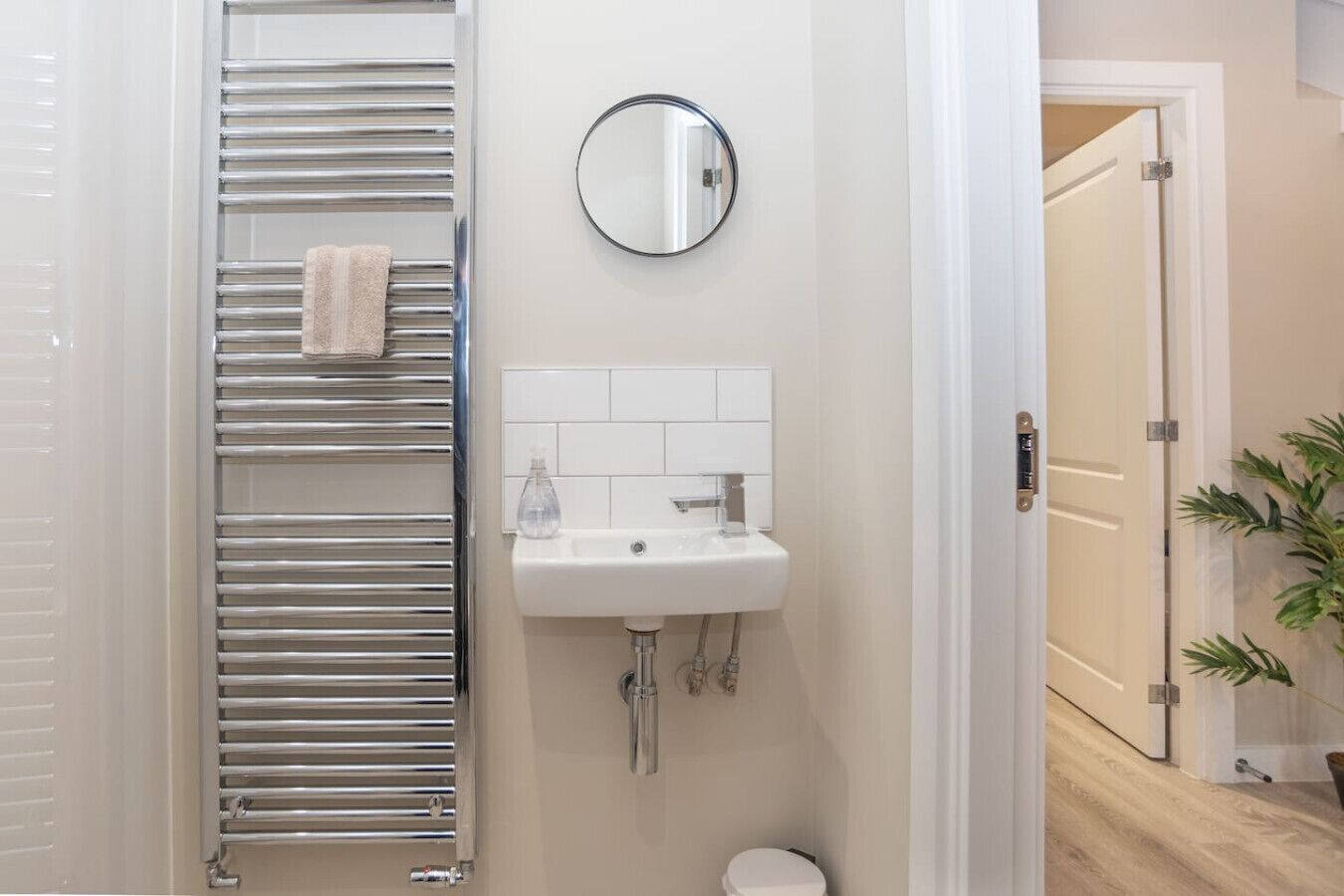 Un baño con toallero, lavabo, espejo y váter.
