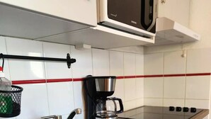 A kitchen with a black sink, a coffee maker, and a microwave. - Chalet for 7 people - Les Flocons du Soleil (LE DEVOLUY)