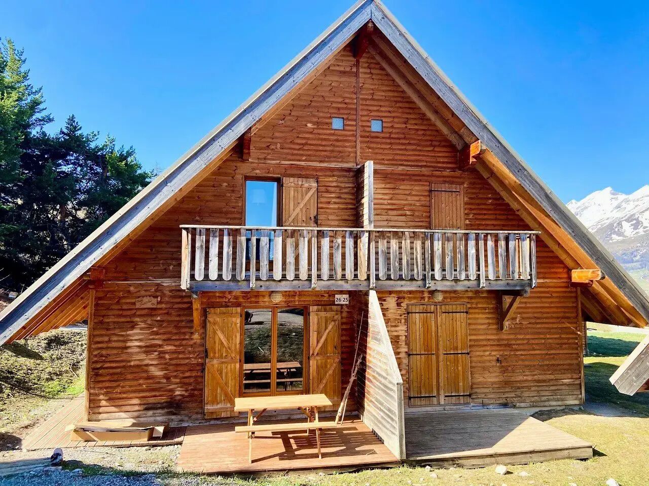 Un chalet en bois doté d’un balcon, d’une porte en bois et d’une petite fenêtre.