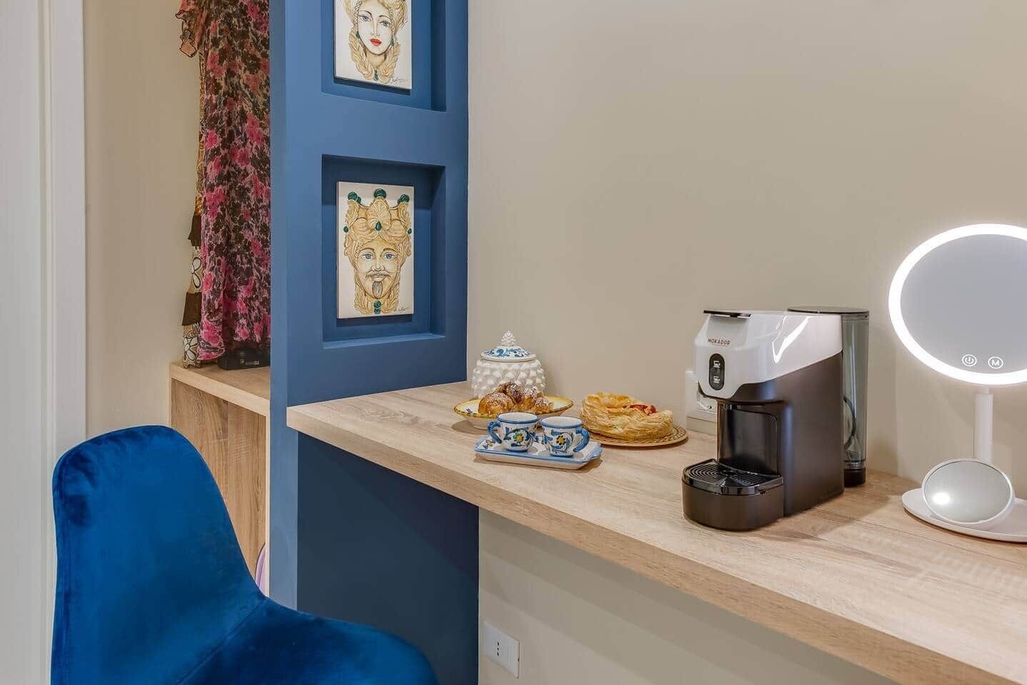 Une pièce comprenant un bureau en bois, une machine à café, un miroir et une chaise.