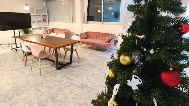 Un salon comprenant une table à manger, deux canapés, un sapin de Noël et un téléviseur.