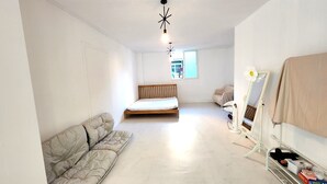 Une chambre à coucher avec un lit, un canapé, un miroir et un radiateur.