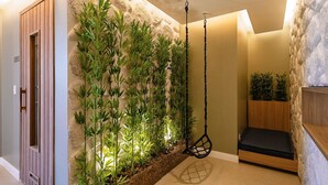 A room with a bed, a hanging chair, and a wall with vertical plants. - Complete Studio 350 m From the Subway Ipi0034 (São Paulo)