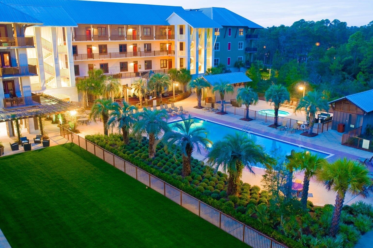 A hotel with multiple floors, outdoor pool, and palm trees.