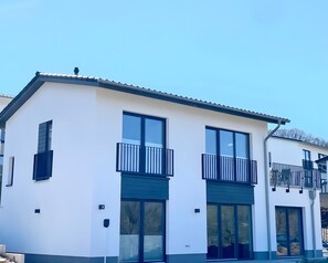 A modern two-story building with large windows, a balcony, and a flat roof. - Holiday Home Mena at Lake Diemelsee (Diemelsee)