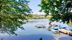 A calm lake with docked boats and a bench by the water's edge. - Holiday Home Mena at Lake Diemelsee (Diemelsee)