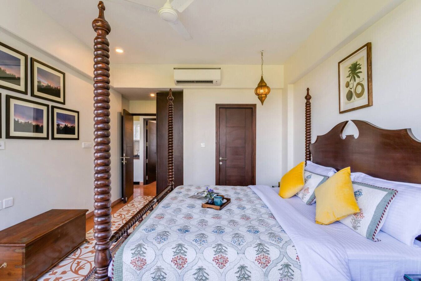 A bedroom with a four-poster bed, a wooden headboard, and a hanging light fixture.