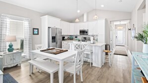Een moderne keuken met witte kasten, roestvrijstalen apparatuur en een centraal eiland.