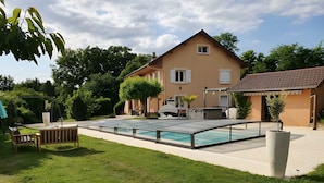 Une maison avec une piscine, une terrasse et un jardin.