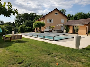 Une maison avec une piscine, une terrasse et un jardin.