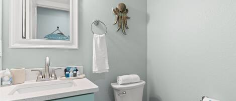 Un baño con lavamanos, inodoro y espejo.