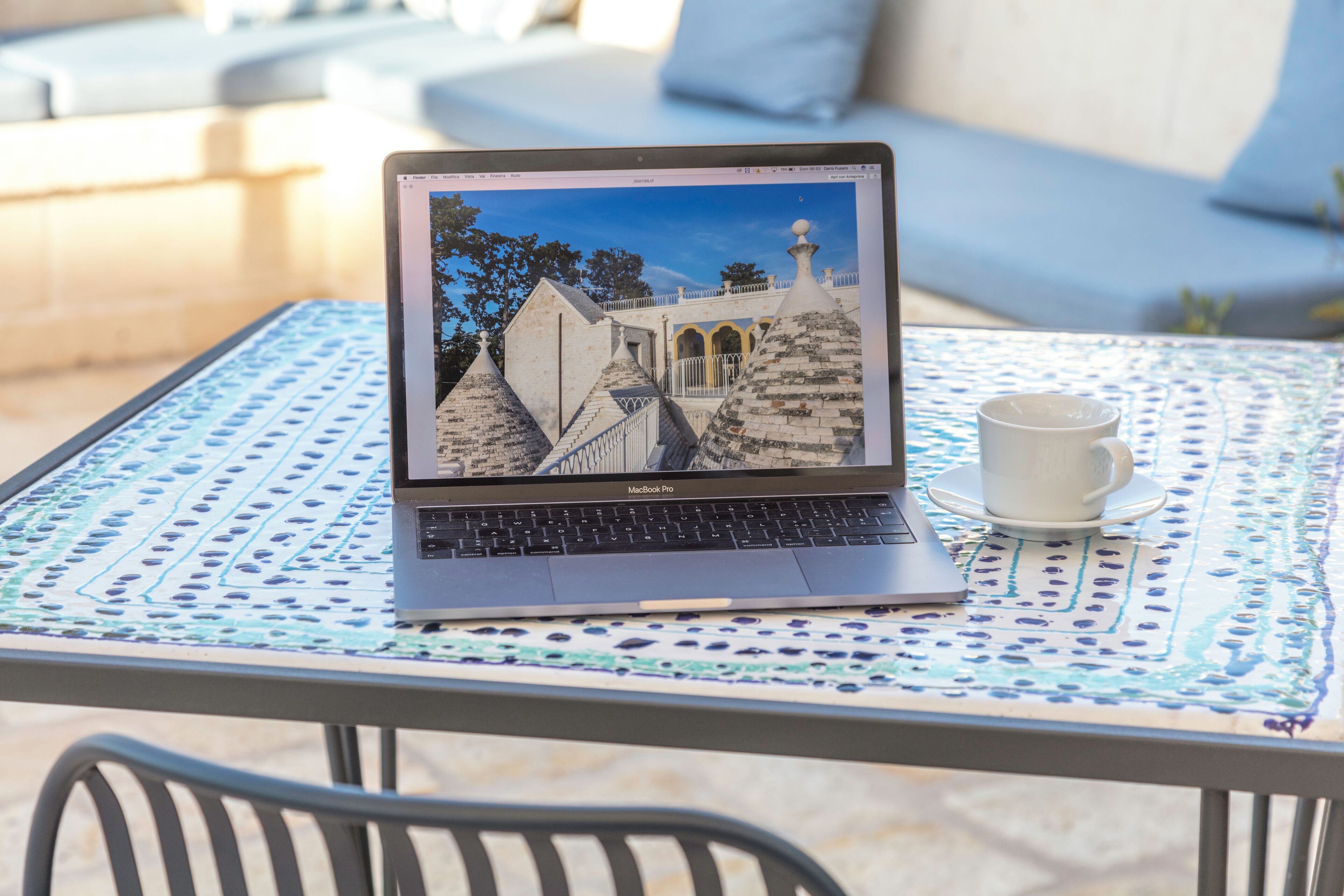 A laptop on a table with a view of a building.