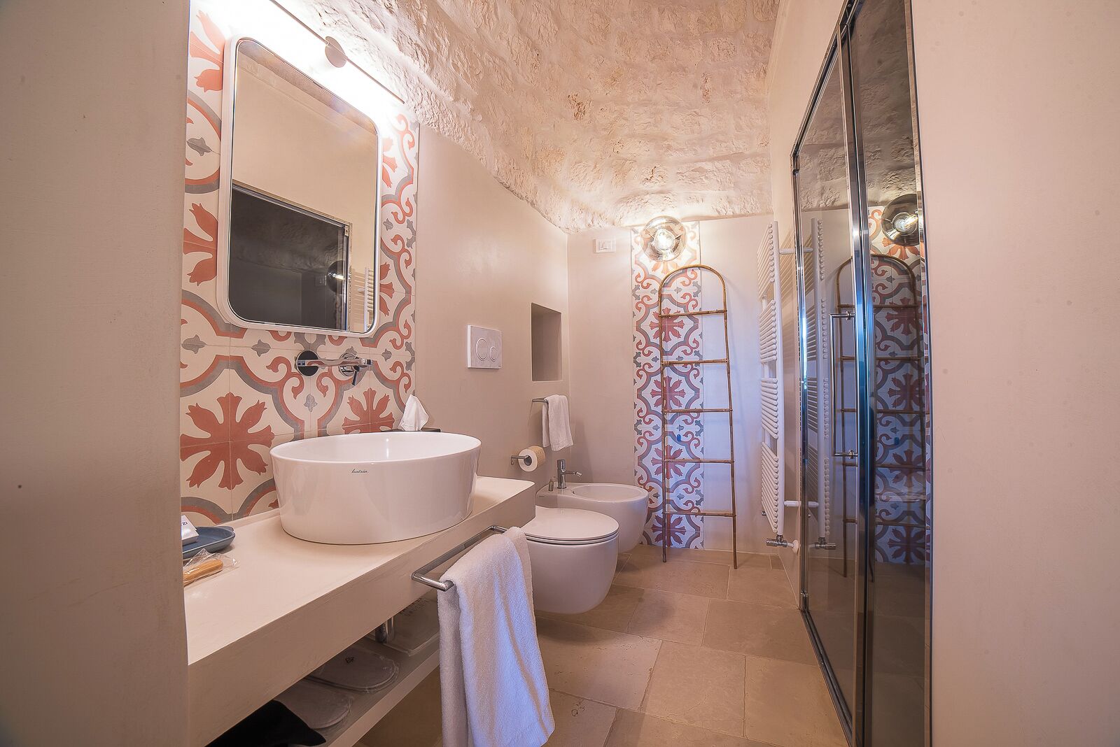 Ein Badezimmer mit großem Waschbecken, Toilette und Duschbereich.